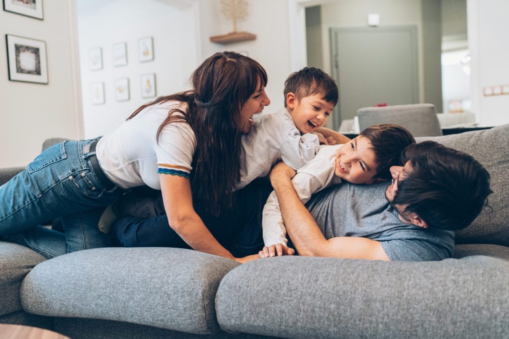 famille qui s'amuse sur un canapé