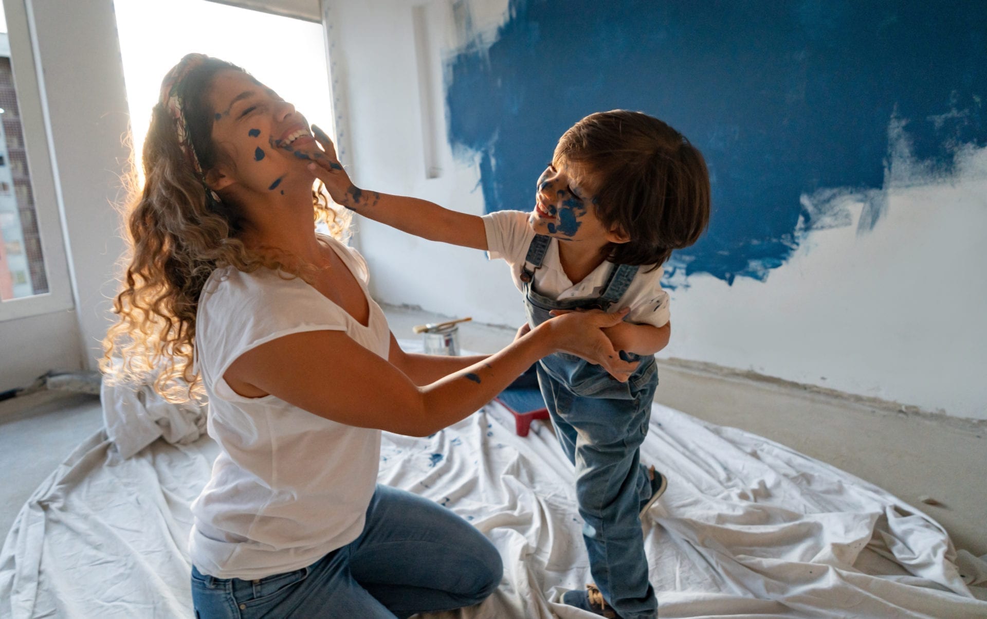 une maman avec son fils qui fait une bataille de peinture